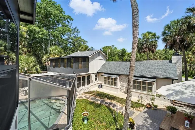 an aerial view of residential houses with outdoor space and trees