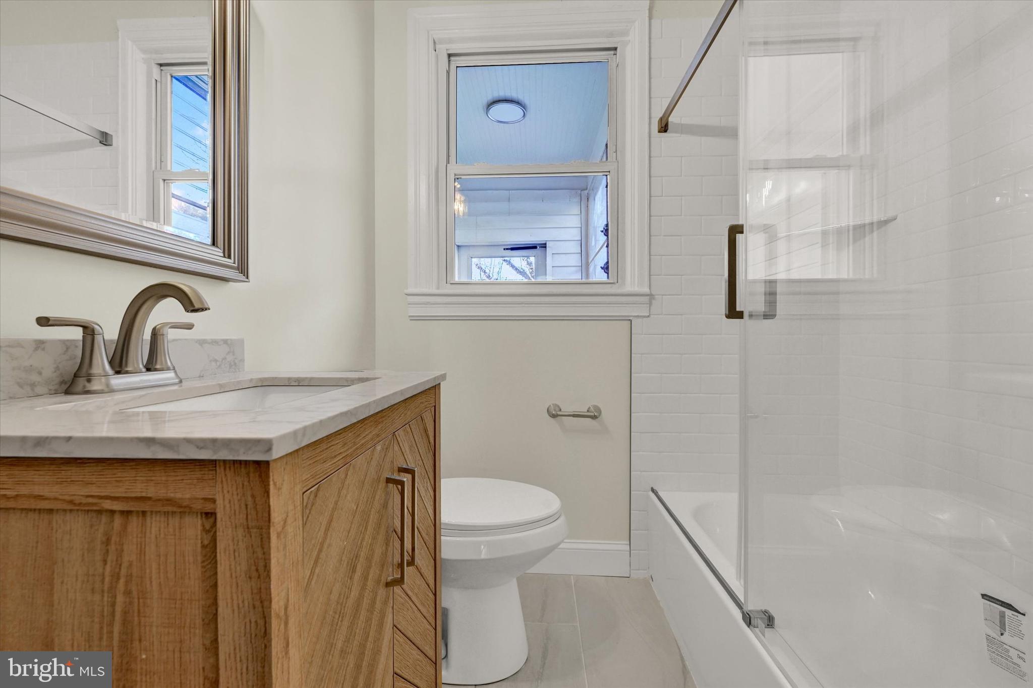 1032 Elm Ridge Avenue Baltimore, MD 21229 - Photo 12 of 28 a bathroom with a sink a toilet and shower