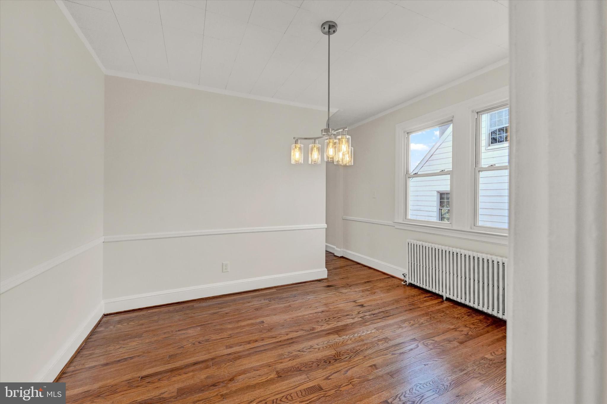 1032 Elm Ridge Avenue Baltimore, MD 21229 - Photo 14 of 28 a view of an empty room with wooden floor and a window
