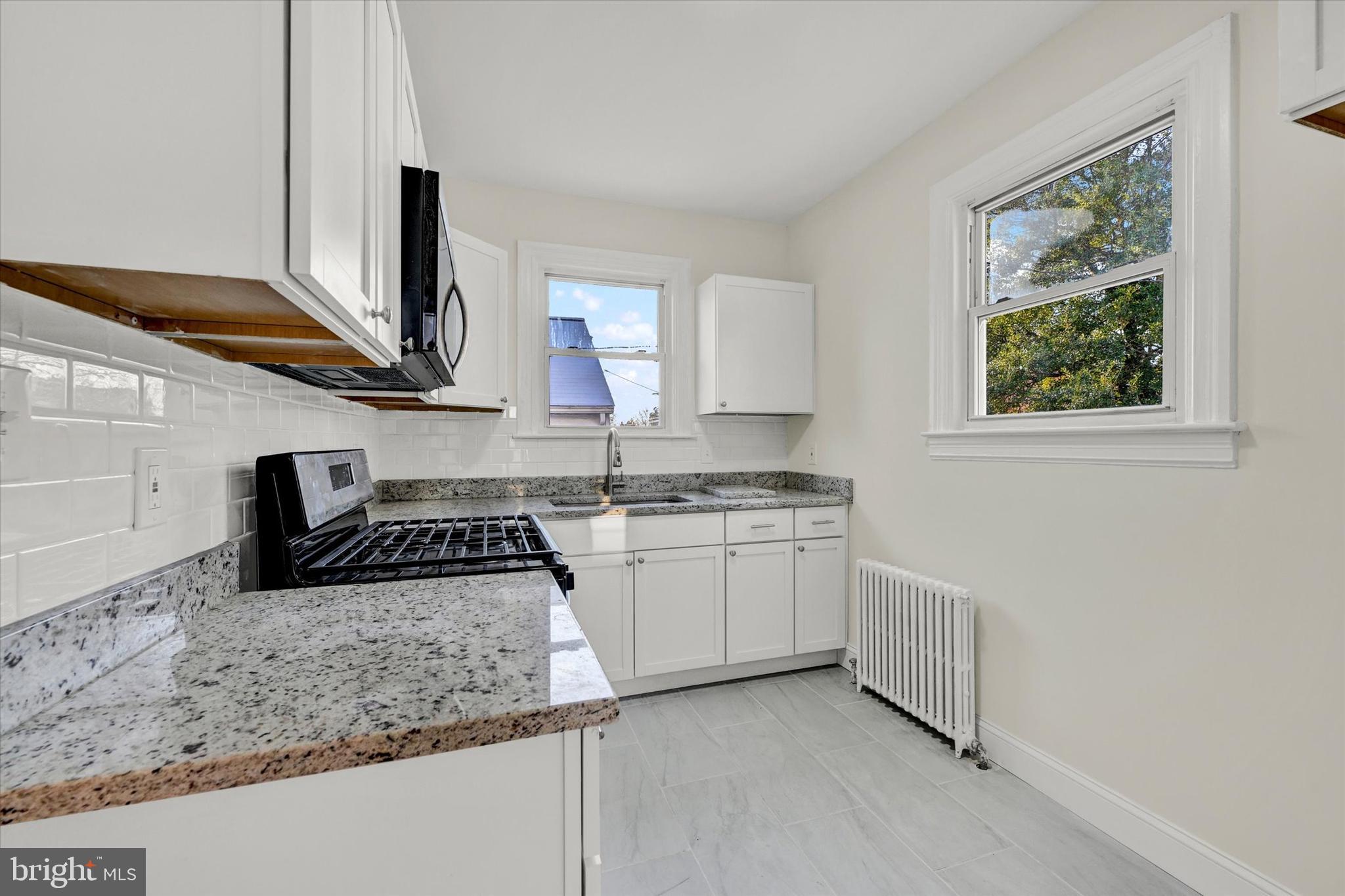 1032 Elm Ridge Avenue Baltimore, MD 21229 - Photo 15 of 28 a kitchen with stainless steel appliances granite countertop a sink stove and cabinets