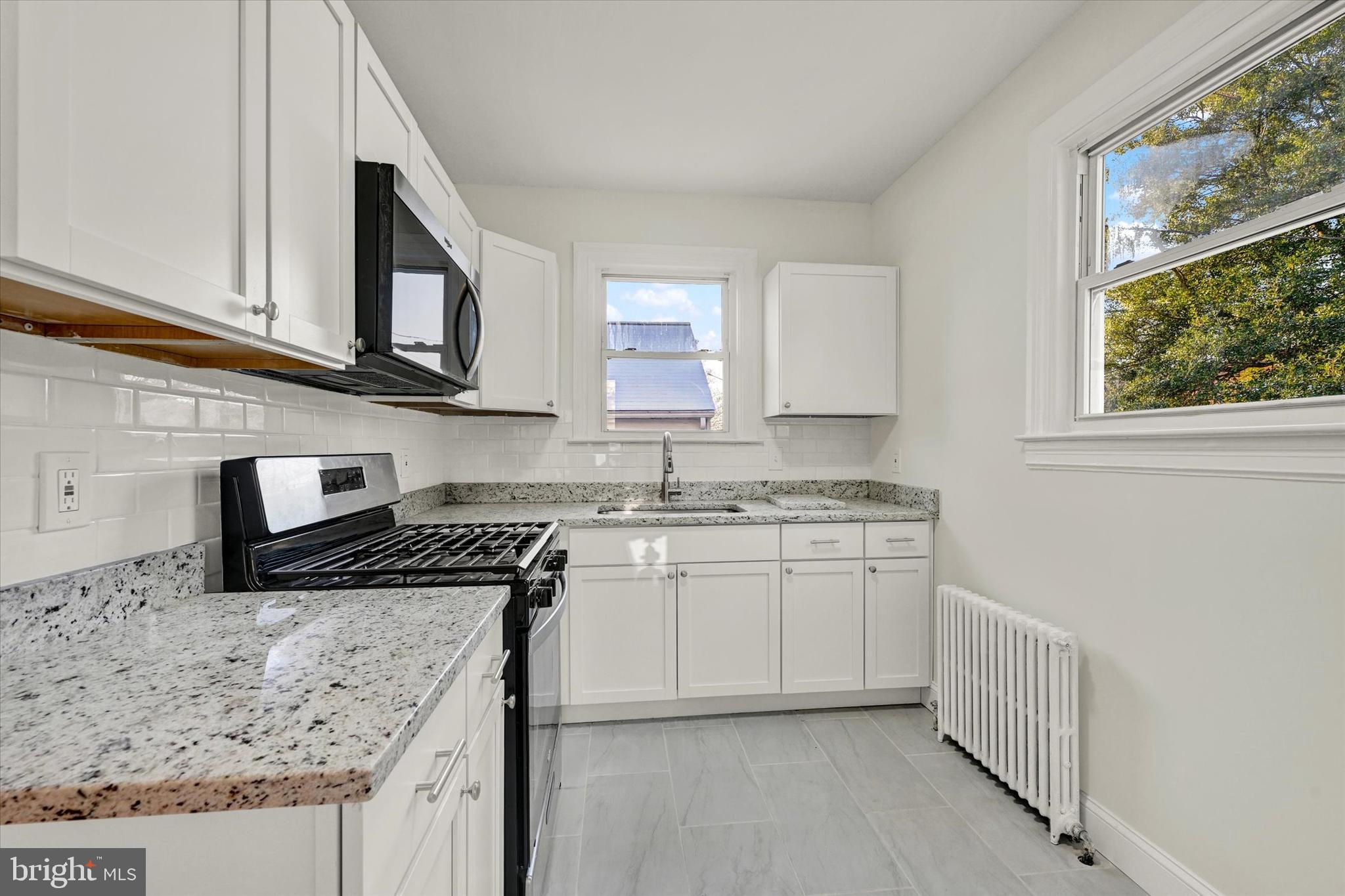 1032 Elm Ridge Avenue Baltimore, MD 21229 - Photo 17 of 28 a kitchen with stainless steel appliances granite countertop a sink stove and microwave