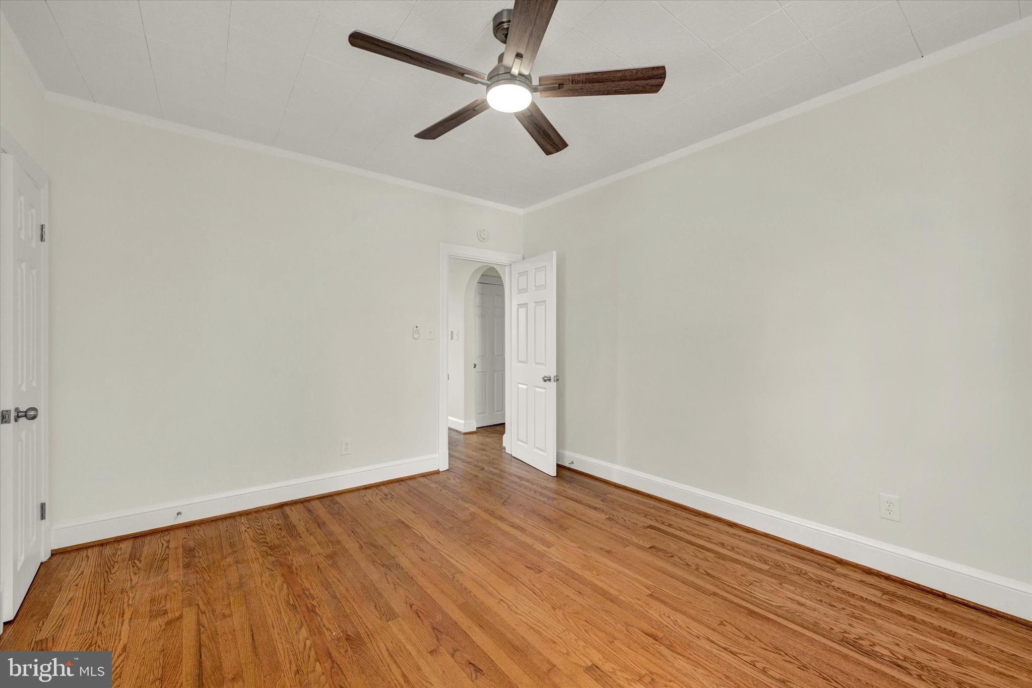 1032 Elm Ridge Avenue Baltimore, MD 21229 - Photo 9 of 28 an empty room with wooden floor and a ceiling fan