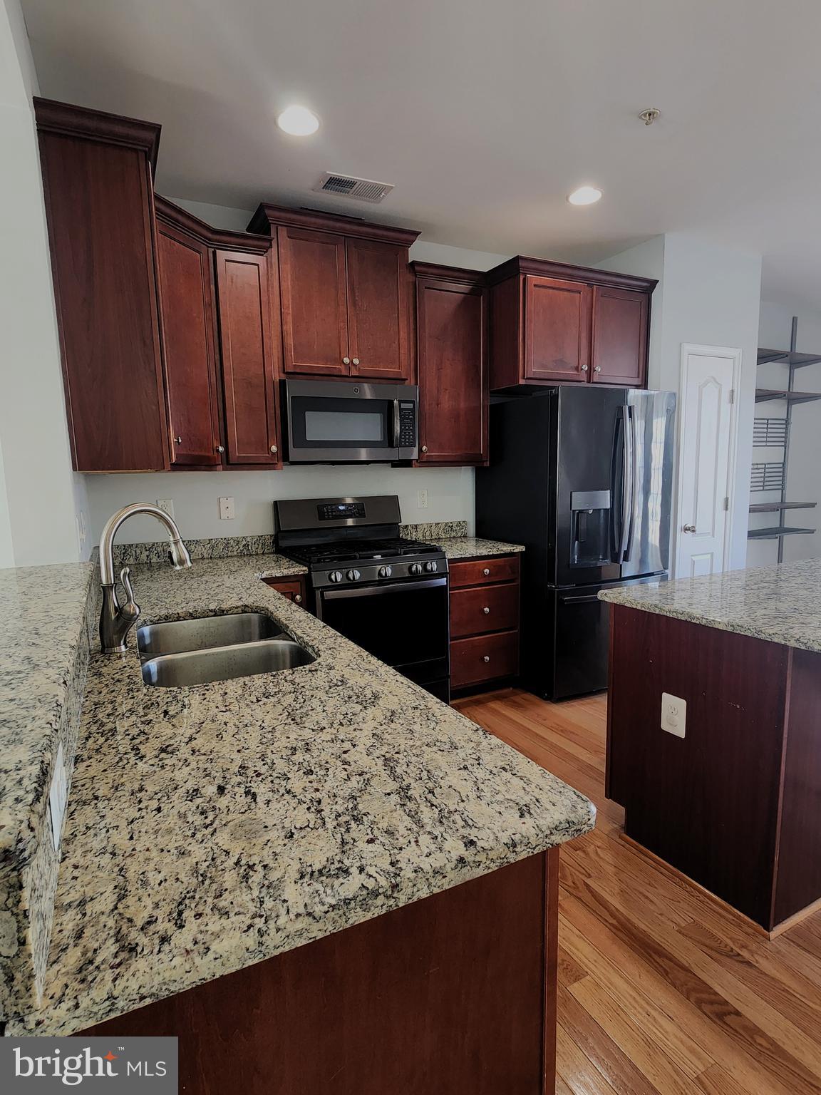 102 Mill Pond Road Frederick, MD 21701 - Photo 29 of 29 a kitchen with stainless steel appliances wooden cabinets a refrigerator and a sink