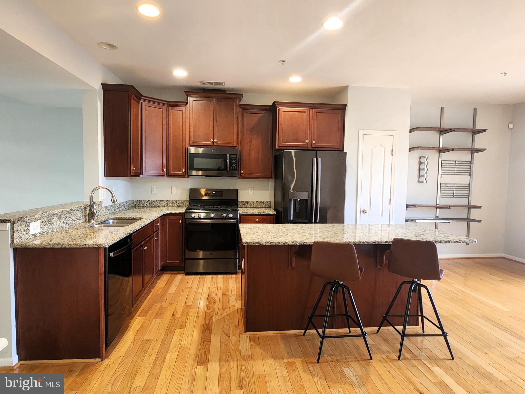 102 Mill Pond Road Frederick, MD 21701 - Photo 6 of 29 a large kitchen with stainless steel appliances kitchen island granite countertop a refrigerator a stove a sink a dining table and chairs