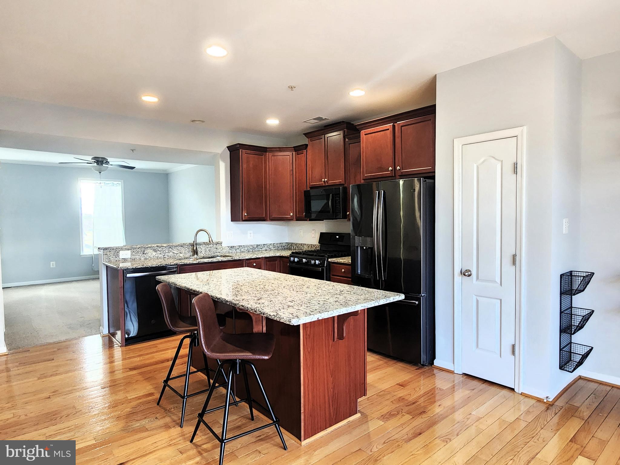 102 Mill Pond Road Frederick, MD 21701 - Photo 8 of 29 a kitchen with stainless steel appliances granite countertop a table chairs sink refrigerator and cabinets