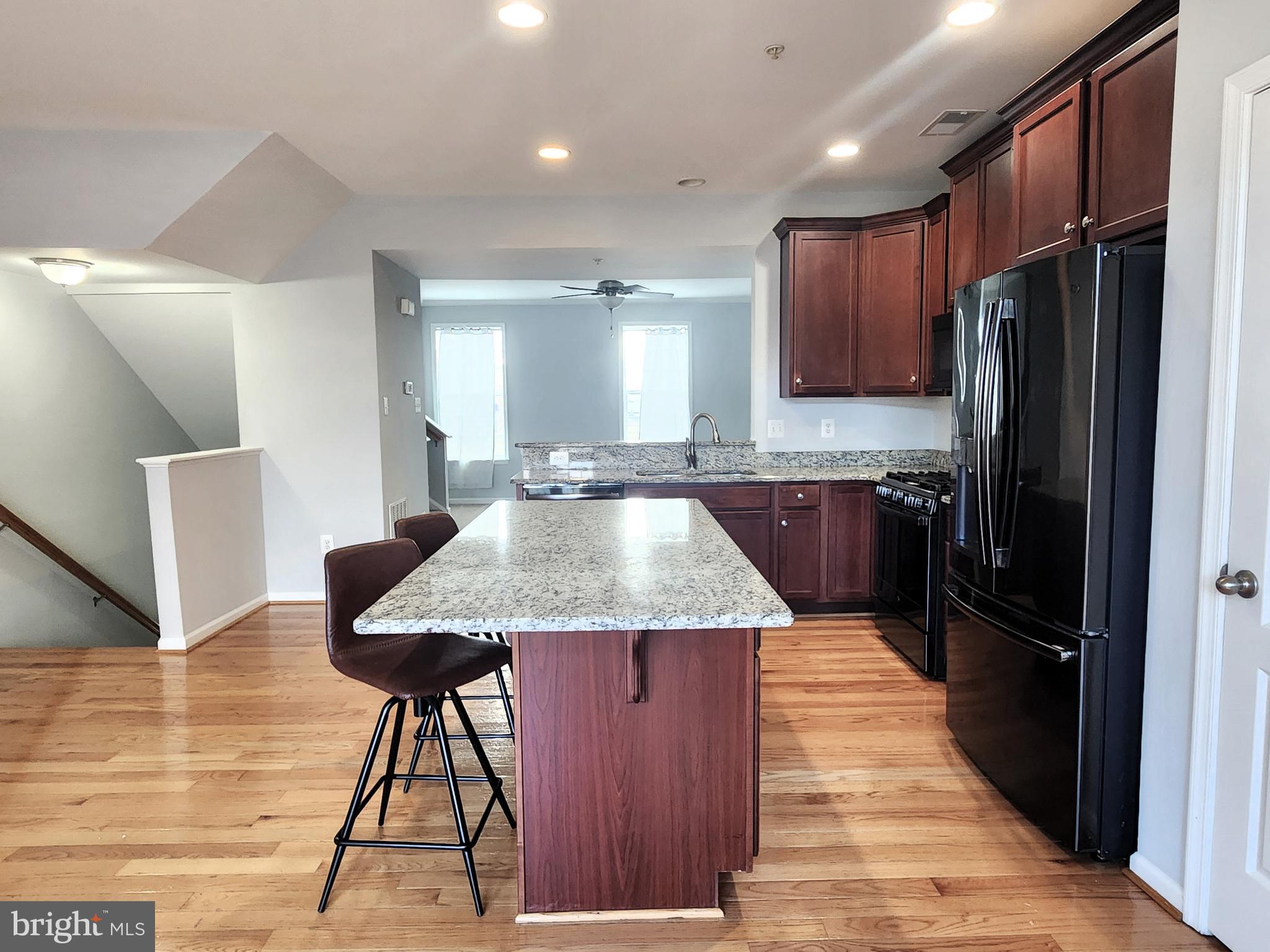 102 Mill Pond Road Frederick, MD 21701 - Photo 9 of 29 a kitchen with stainless steel appliances kitchen island granite countertop wooden cabinets a refrigerator a sink and dishwasher