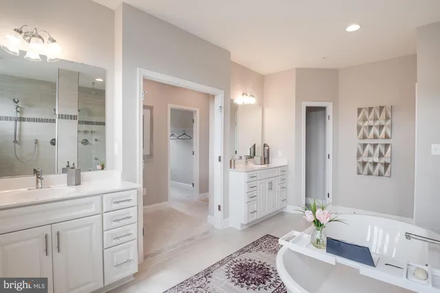 a spacious bathroom with a double vanity sink a mirror a bathtub and
