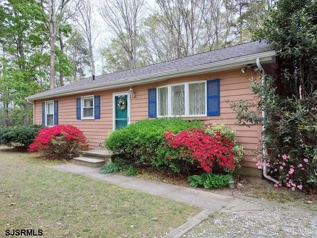a front view of a house with a yard and a garden