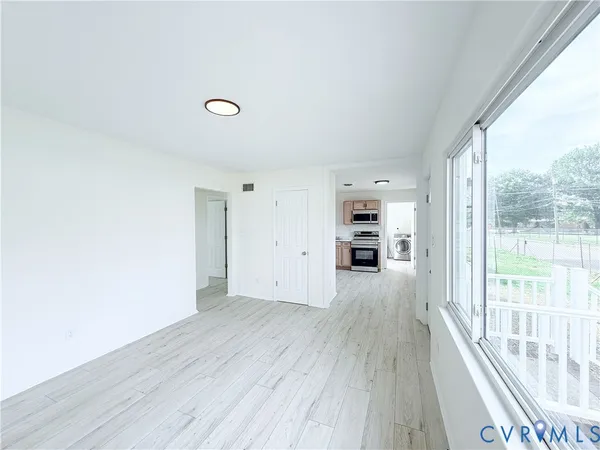 a view of a room with wooden floor and windows