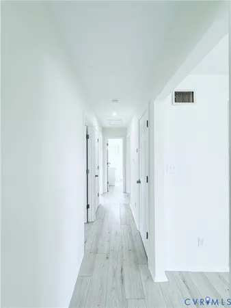 a view of a hallway with wooden floor