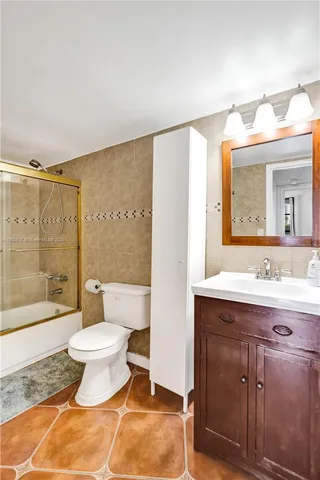 a bathroom with a bathtub shower sink mirror and toilet