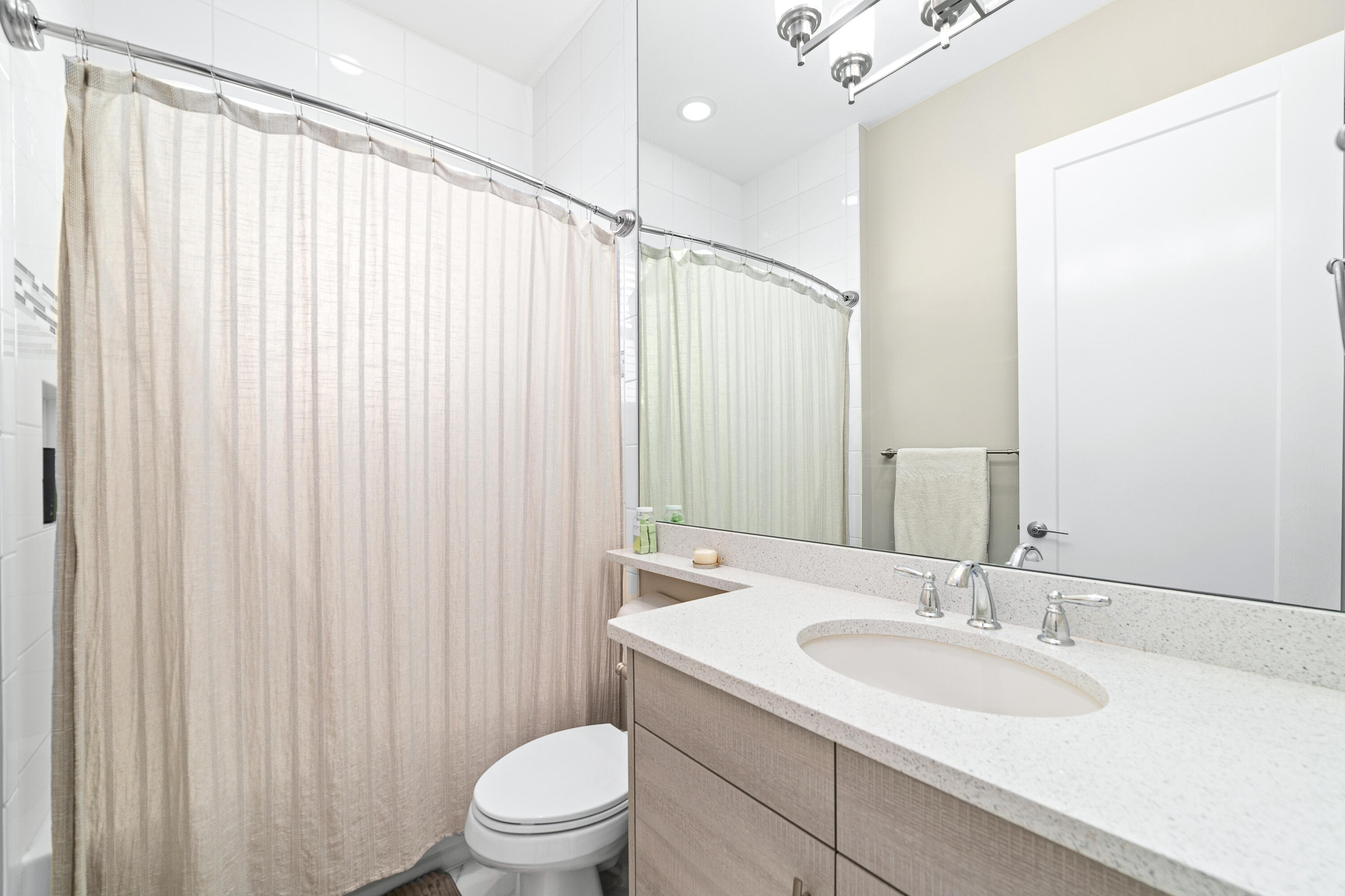 15380 Blue River Road Delray Beach, FL 33446 - Photo 18 of 31 a bathroom with a sink a toilet and shower curtain
