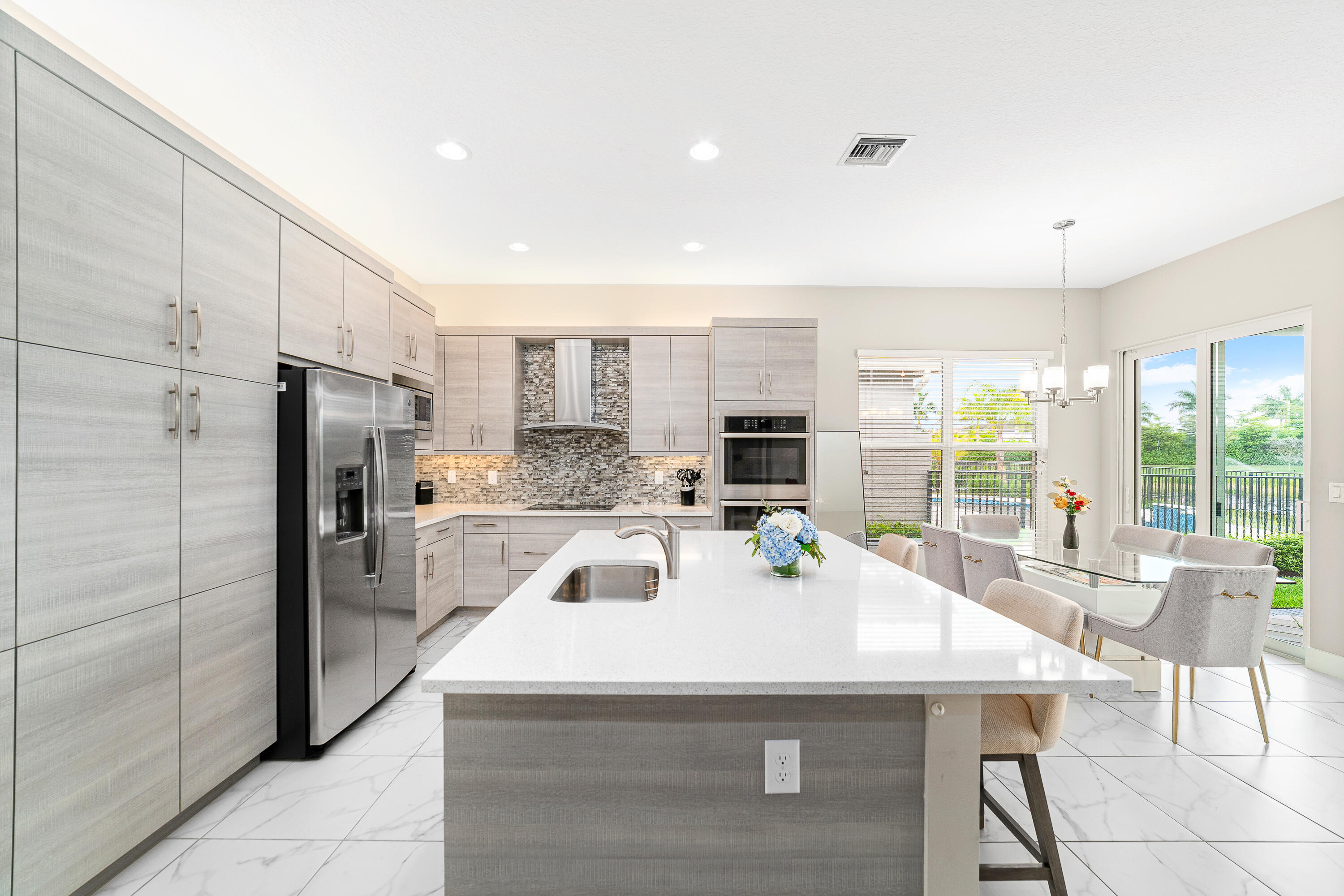15380 Blue River Road Delray Beach, FL 33446 - Photo 6 of 31 a kitchen with a sink a counter top stainless steel appliances and cabinets
