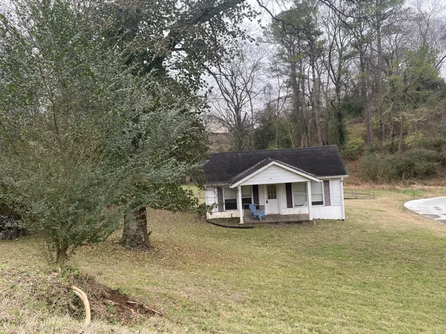 a front view of a house with a yard and lake view