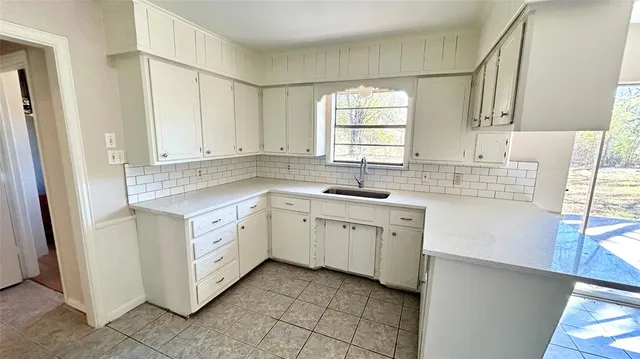 a kitchen with granite countertop white cabinets and white appliances