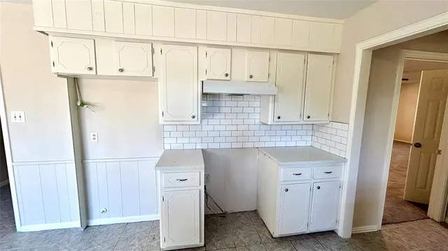 a kitchen with cabinets and a refrigerator