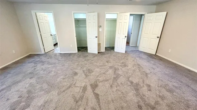an empty room with closet and mirror