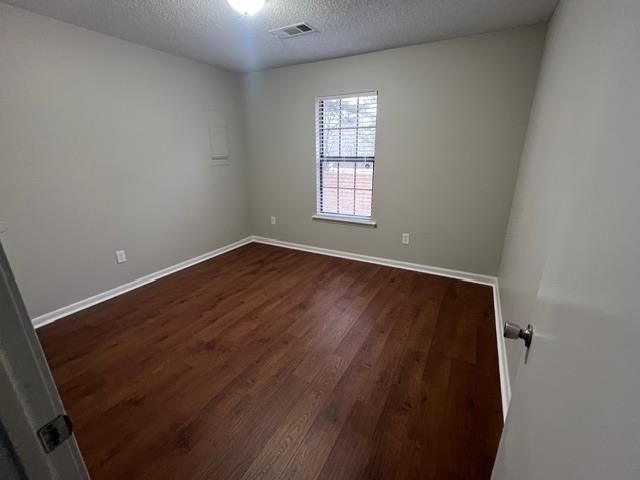 2541 Ray Bluff Road Millington, TN 38053 - Photo 10 of 12 Empty room with a textured ceiling and dark wood-style floors