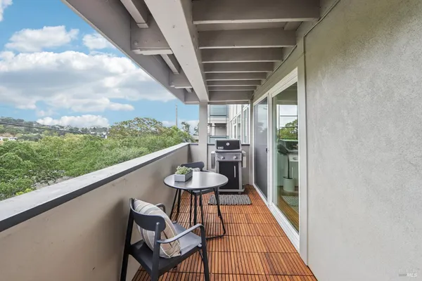 a balcony with chairs and a table