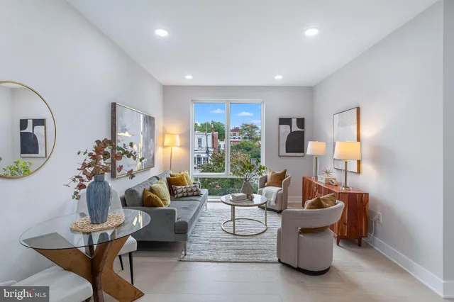 a living room with fireplace furniture and a large window