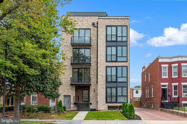 a front view of a residential apartment building with a yard