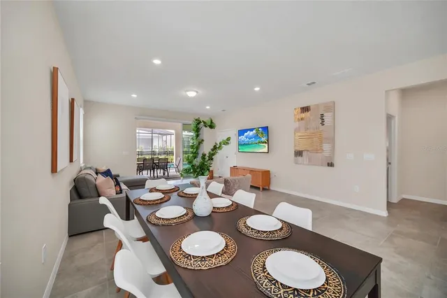 a dining room with furniture a lamp and wooden floor