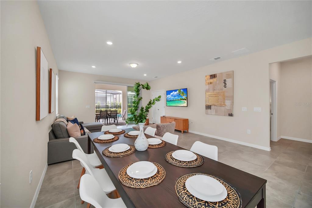7196 Oakmoss Loop Davenport, FL 33837 - Photo 15 of 48 a dining room with furniture a lamp and wooden floor