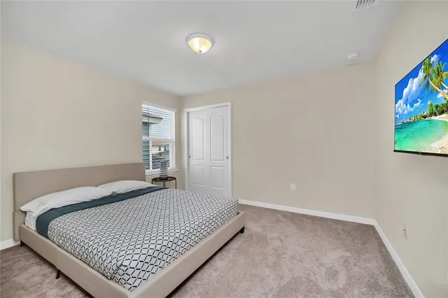 a bedroom with a bed and painting on the wall