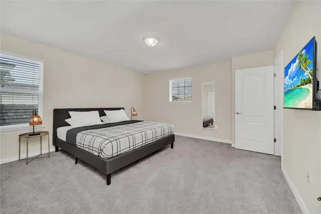 a bed sitting in a bedroom and a flat screen tv