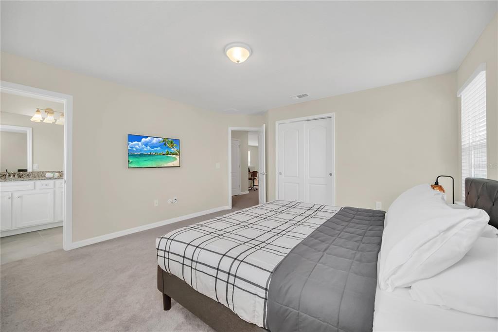 7196 Oakmoss Loop Davenport, FL 33837 - Photo 22 of 48 a bedroom with a bed and a view of kitchen