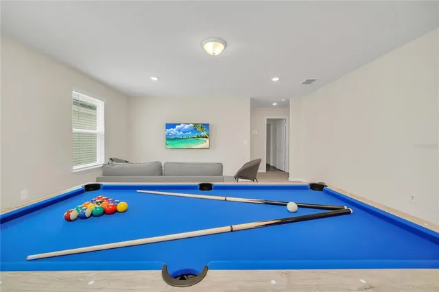a room with pool table and windows