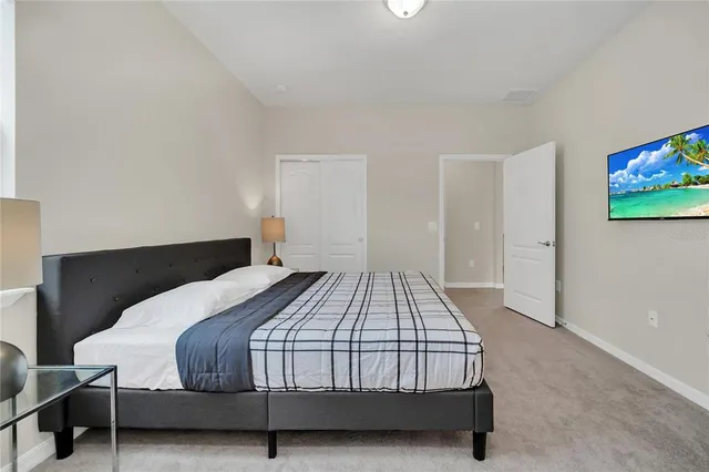 a bedroom with a bed and a flat screen tv