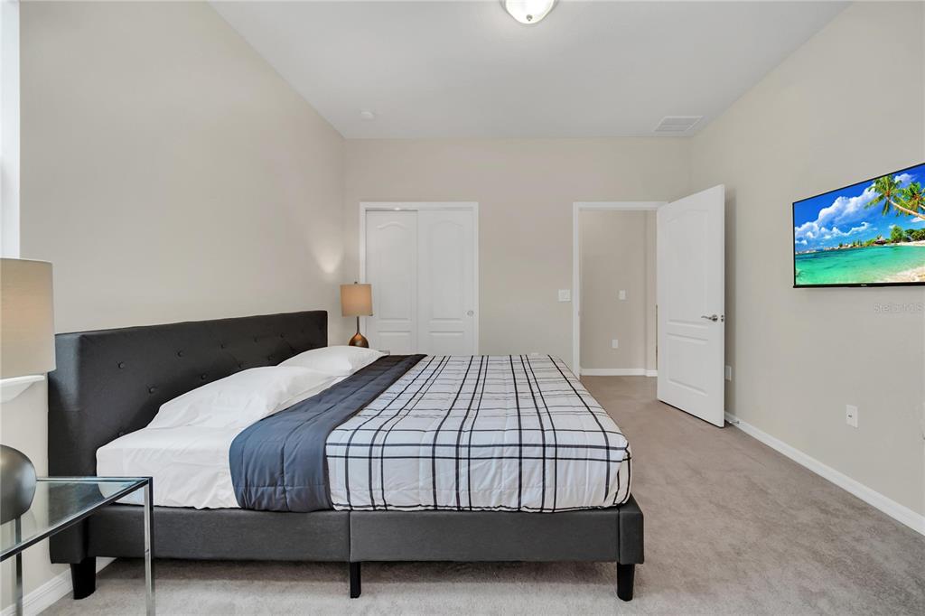 7196 Oakmoss Loop Davenport, FL 33837 - Photo 39 of 48 a bedroom with a bed and a flat screen tv