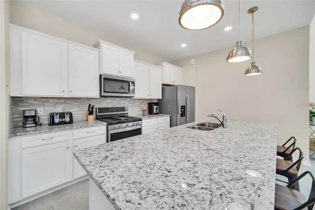 a kitchen with stainless steel appliances granite countertop a sink a stove and cabinets