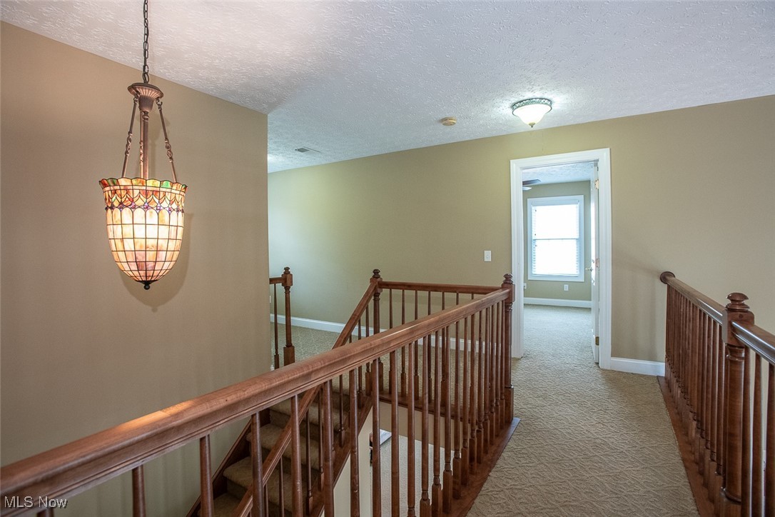 630 Rundle Street Lagrange, OH 44050 - Photo 27 of 49 Corridor featuring carpet floors, a textured ceiling, and an upstairs landing