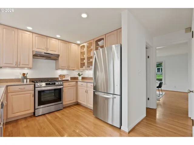 a kitchen with granite countertop a refrigerator and a stove top oven