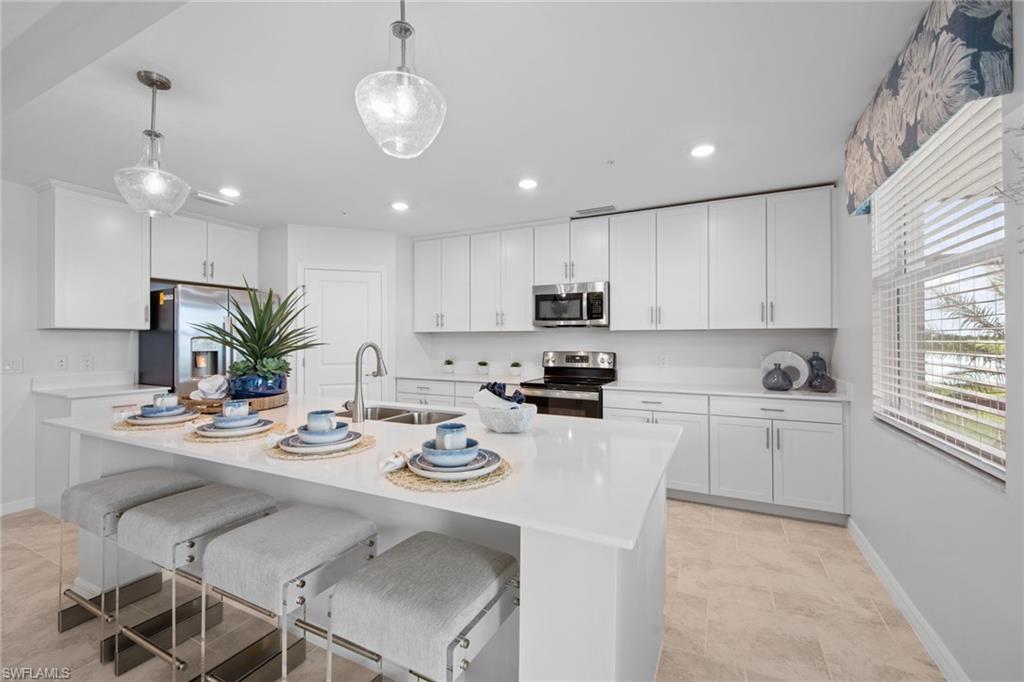6008 Ellerston Way Avenue, Unit 1011 Immokalee, FL 34142 - Photo 12 of 50 Kitchen featuring a breakfast bar, appliances with stainless steel finishes, pendant lighting, white cabinets, and recessed lighting