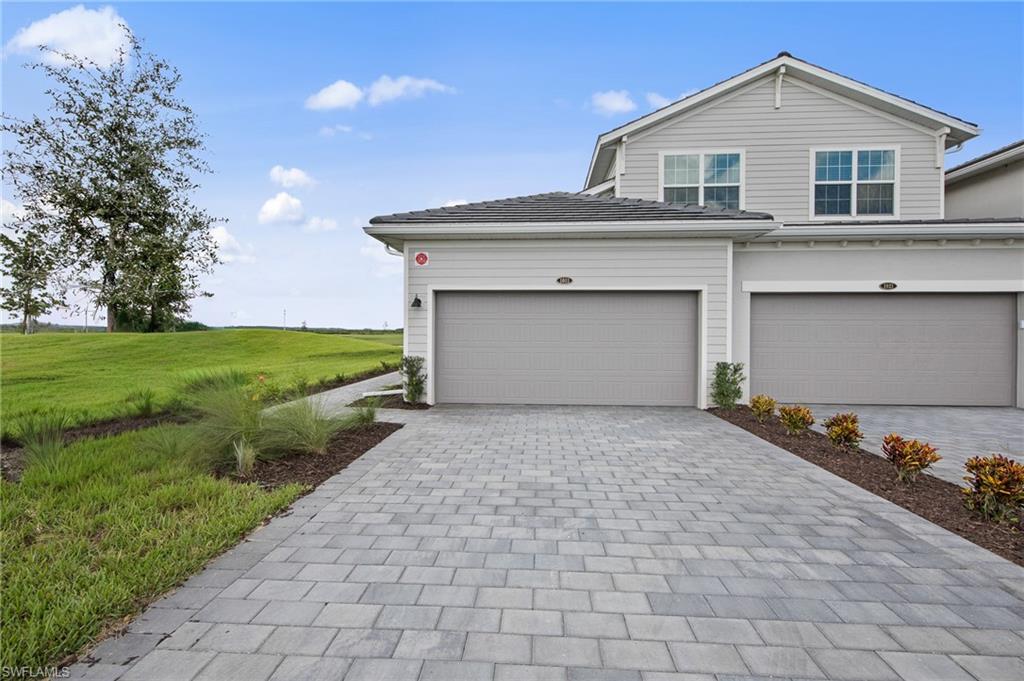 6008 Ellerston Way Avenue, Unit 1011 Immokalee, FL 34142 - Photo 34 of 50 View of front of house featuring decorative driveway, a garage, and a front yard