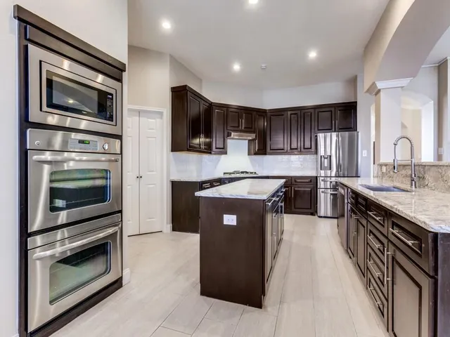 a kitchen with stainless steel appliances granite countertop a stove microwave and sink