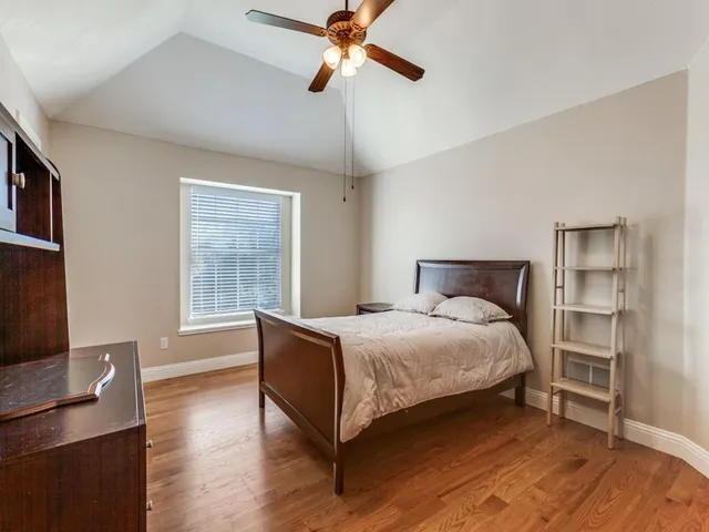 a bedroom with a bed and a flat tv screen on dresser