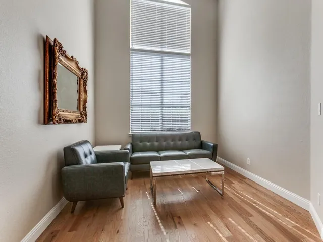 a living room with couches and a window with wooden floor