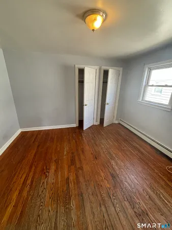 a view of a room with wooden floor and window