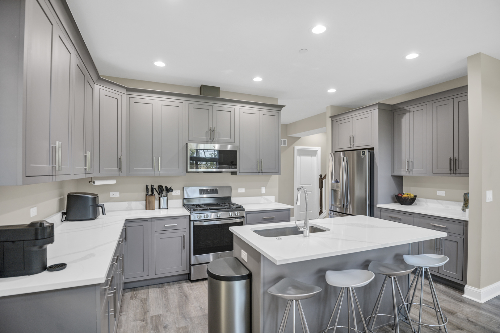 70 Prairie Court Wheeling, IL 60090 - Photo 7 of 44 a kitchen with stainless steel appliances kitchen island a table chairs sink and cabinets