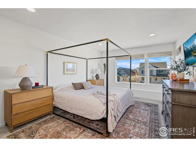 a bedroom with a bed and a large window