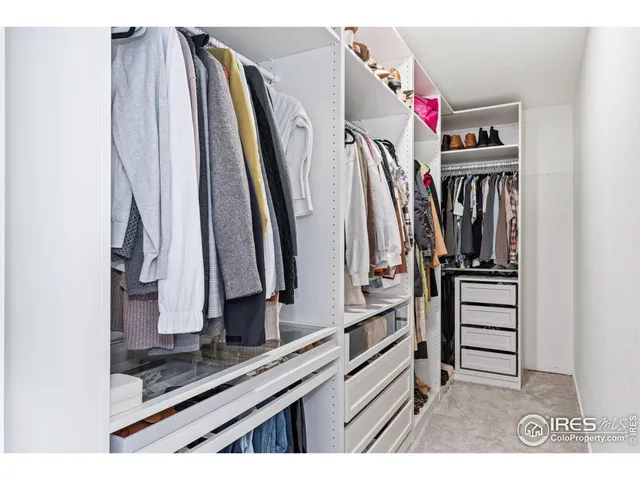 a view of walk in closet with clothes and shoes