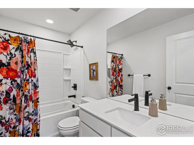a bathroom with a granite countertop sink a toilet and shower