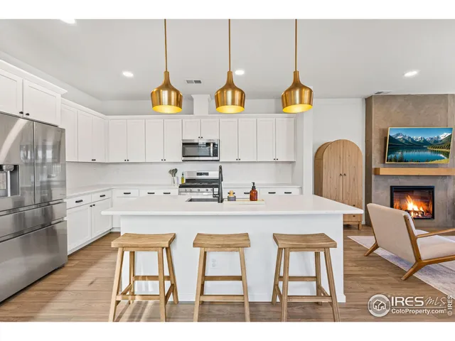a kitchen with stainless steel appliances a stove a refrigerator and a dining table