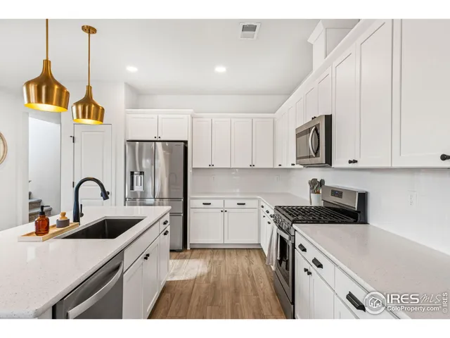 a kitchen with kitchen island granite countertop a sink a stove refrigerator and cabinets