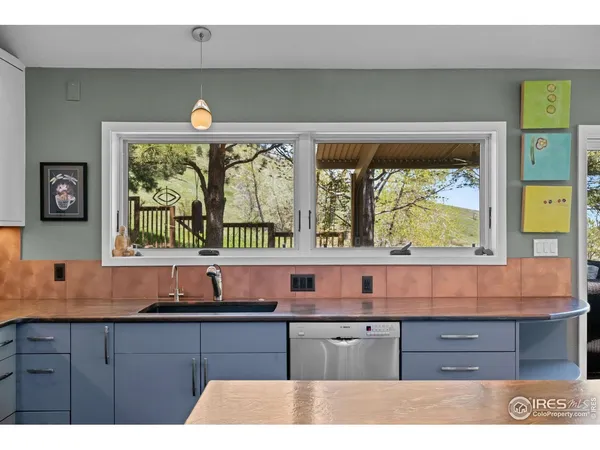 a kitchen with granite countertop a stove a sink and a large window