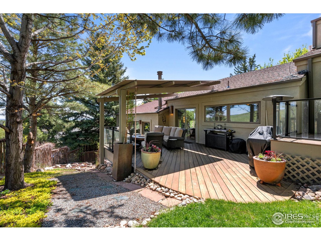 3945 Promontory Court Boulder, CO 80304 - Photo 19 of 33 a view of a patio with table and chairs potted plants and a large tree